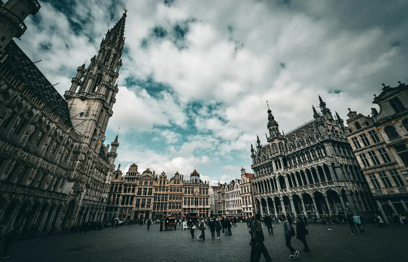 Historische gebouwen met trapgevels rond de Grote Markt in Brussel onder een bewolkte lucht.