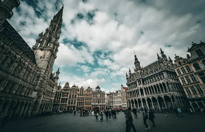 Historische gebouwen met trapgevels rond de Grote Markt in Brussel onder een bewolkte lucht.