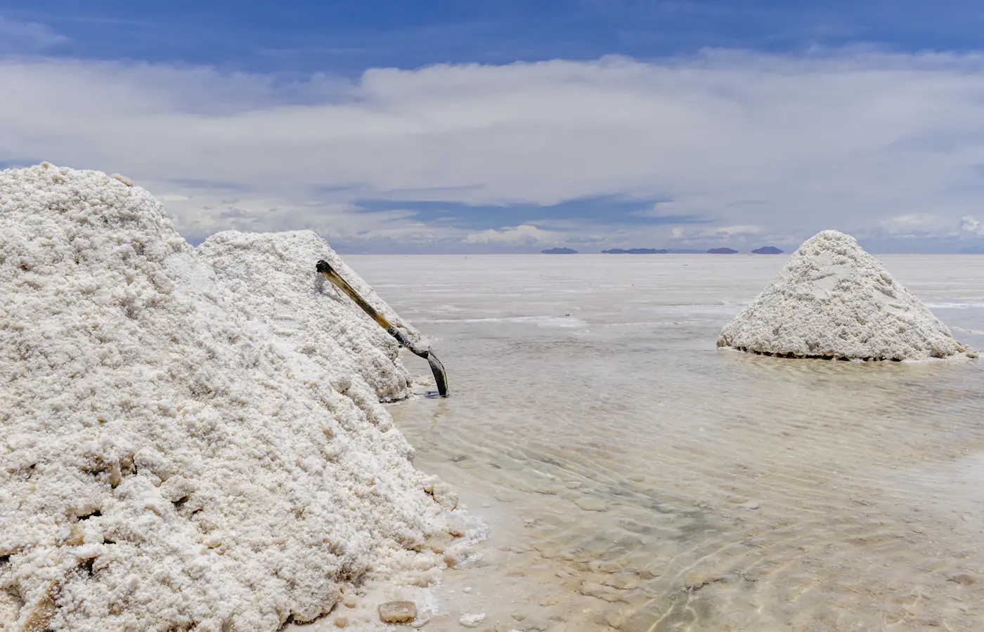 Hopen geoogst zout die uit ondiep water oprijzen op de Salar de Uyuni bij Colchani, Bolivia.