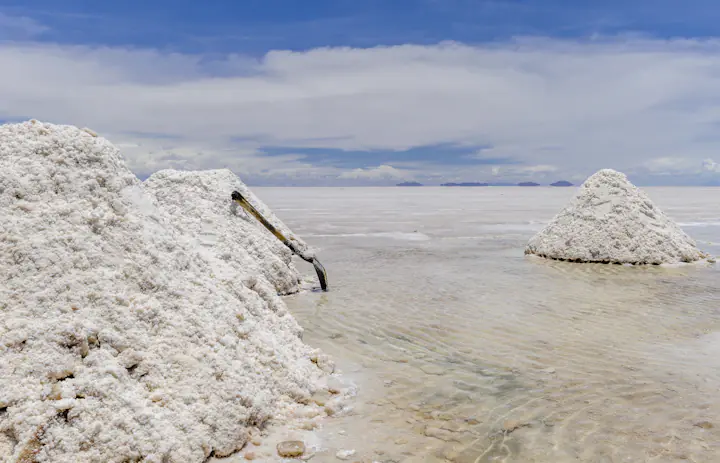 Hopen geoogst zout die uit ondiep water oprijzen op de Salar de Uyuni bij Colchani, Bolivia.