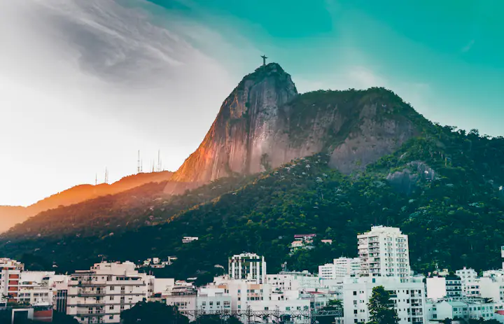 Christ the Redeemer statue on Corcovado, rising above Rio de Janeiro's buildings and wooded hillsides.