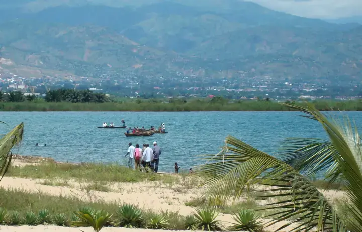 Wooden boats on Lake Tanganyika with Bujumbura and hills behind.