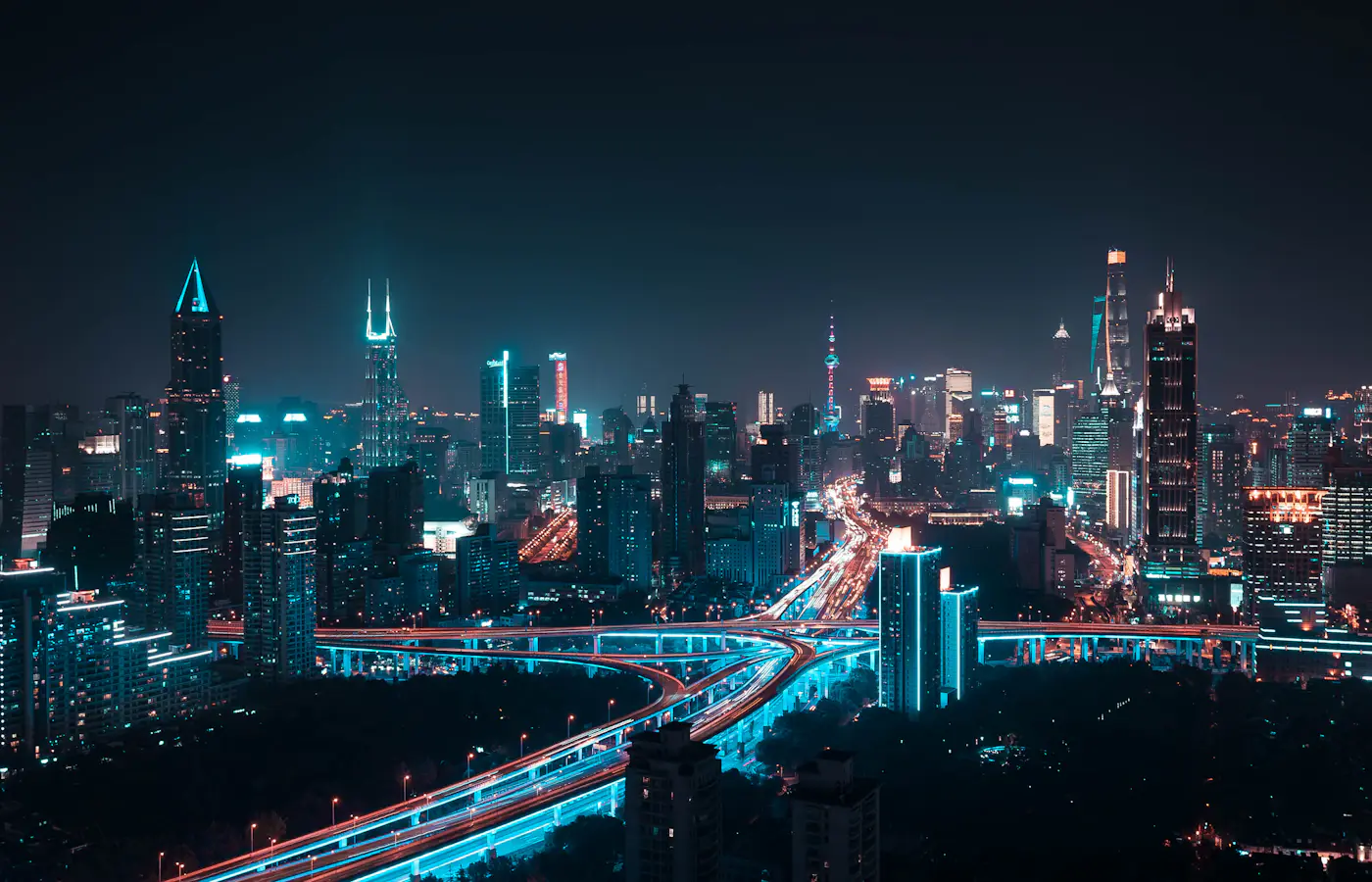 Illuminated Shanghai Pudong skyline at night with elevated roads and skyscrapers in China