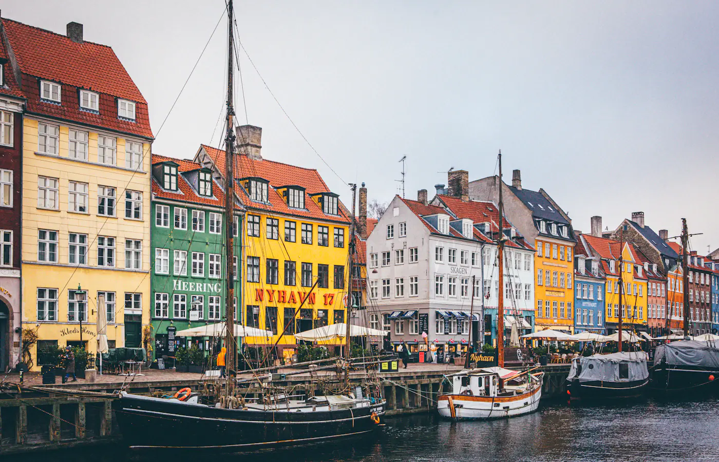 Brightly coloured Nyhavn waterfront houses and moored boats in Copenhagen, Denmark