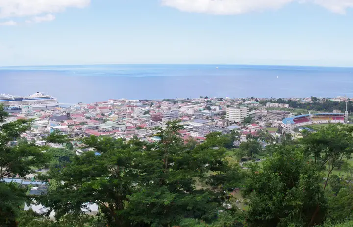 De waterkant en gebouwen van Roseau gezien vanaf een beboste heuvel in Dominica.