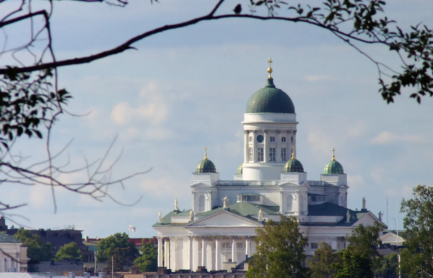 Cattedrale di Helsinki con la sua cupola centrale verde incorniciata da rami d'albero in Finlandia