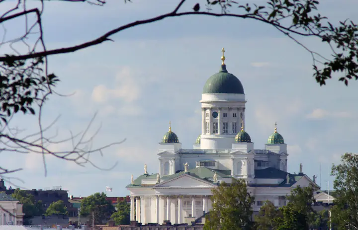 Cattedrale di Helsinki con la sua cupola centrale verde incorniciata da rami d'albero in Finlandia