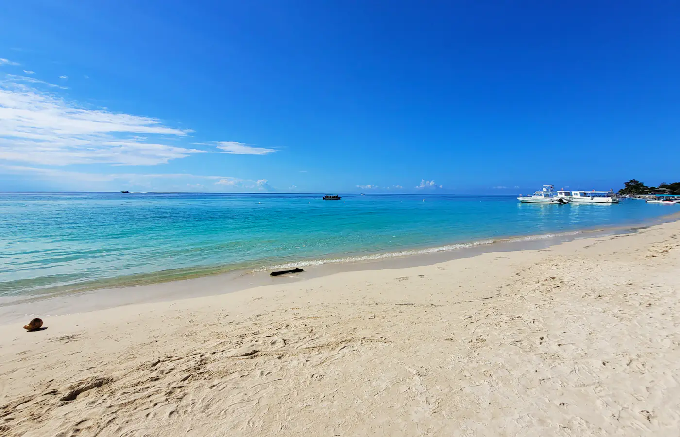 White sand, turquoise water and moored boats at West Bay, Roatán, Honduras