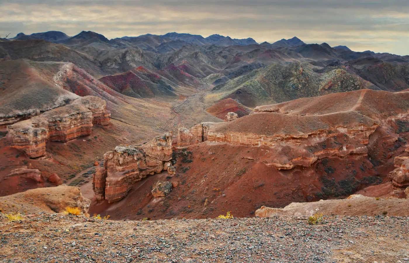 Red rock canyon walls and layered hills at Charyn Canyon in Kazakhstan.