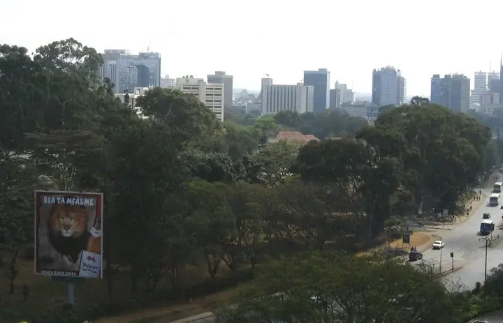 Nairobi skyline viewed from the west above trees and a city road