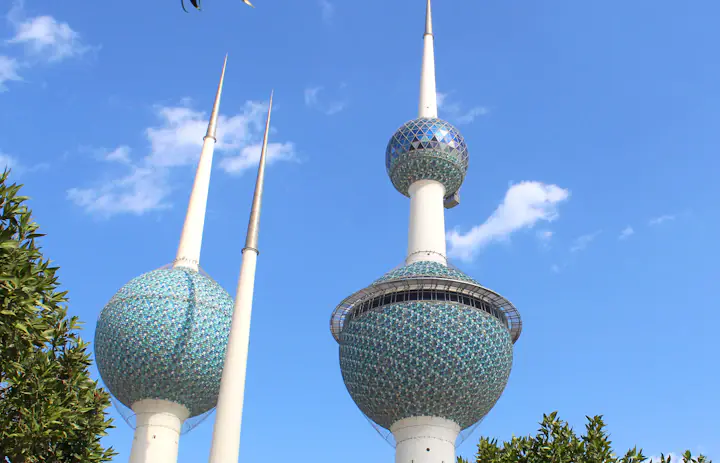 The blue-green tiled spheres of Kuwait Towers against a clear sky