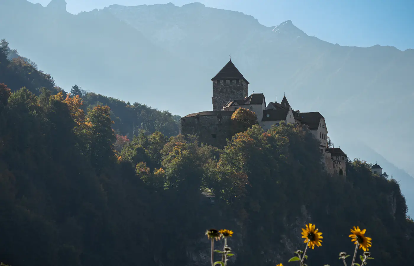 Castello di Vaduz sopra pendii boscosi con cime montuose sullo sfondo, in Liechtenstein