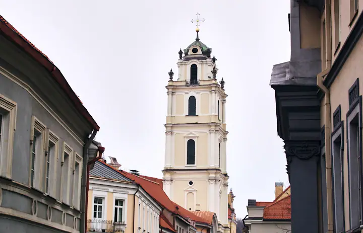 A pale church tower above the narrow streets and tiled roofs of Vilnius.
