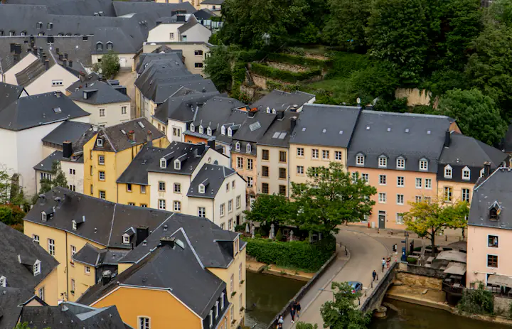 View of houses and the Rue Münster bridge along the river in Luxembourg City's Grund area.