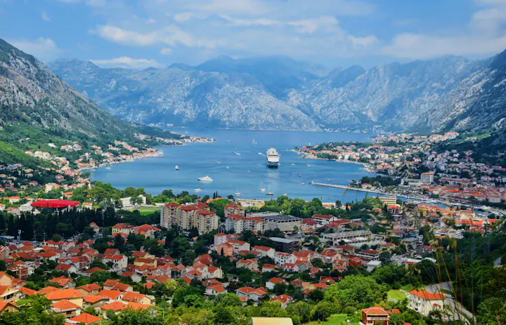 Rot gedeckte Gebäude von Kotor unter den Bergen rund um die Bucht von Kotor, Montenegro