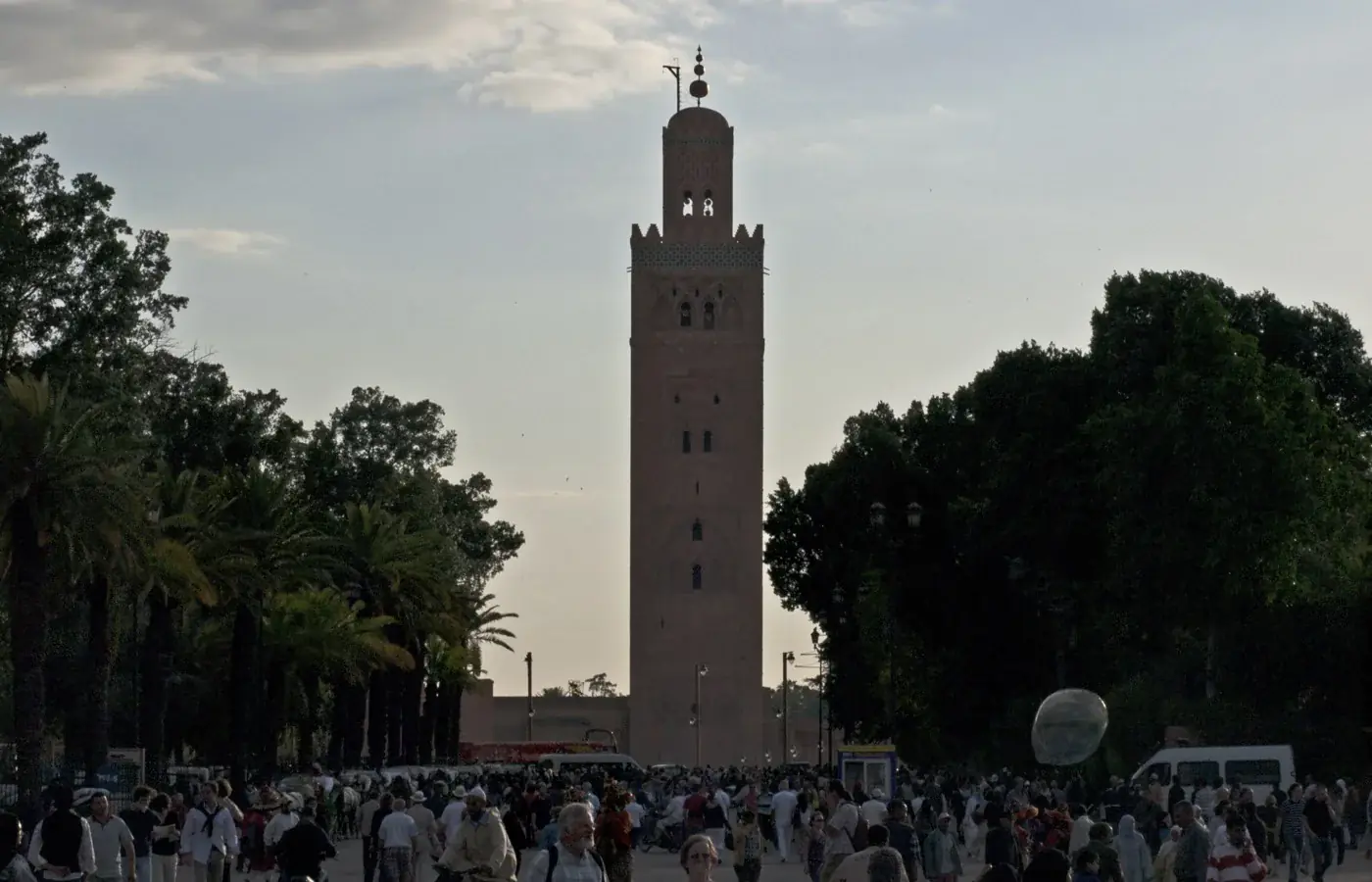 Minareto della Koutoubia visto dietro persone che camminano vicino a Jemaa el-Fnaa a Marrakesh