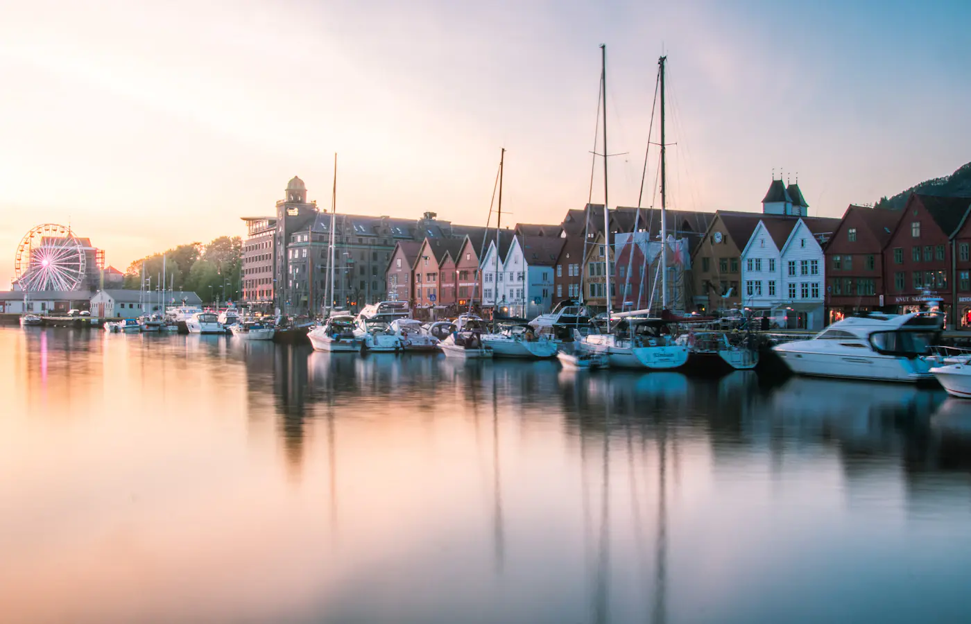 Łodzie i pomalowane domy nad wodą wzdłuż nabrzeża Bryggen w Bergen w Norwegii