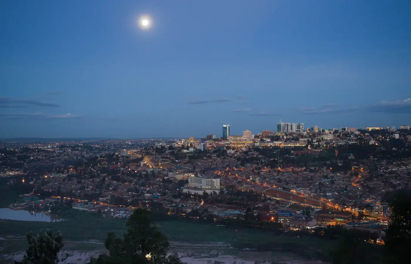 Evening skyline of central Kigali with hillside lights under the moon, Rwanda.