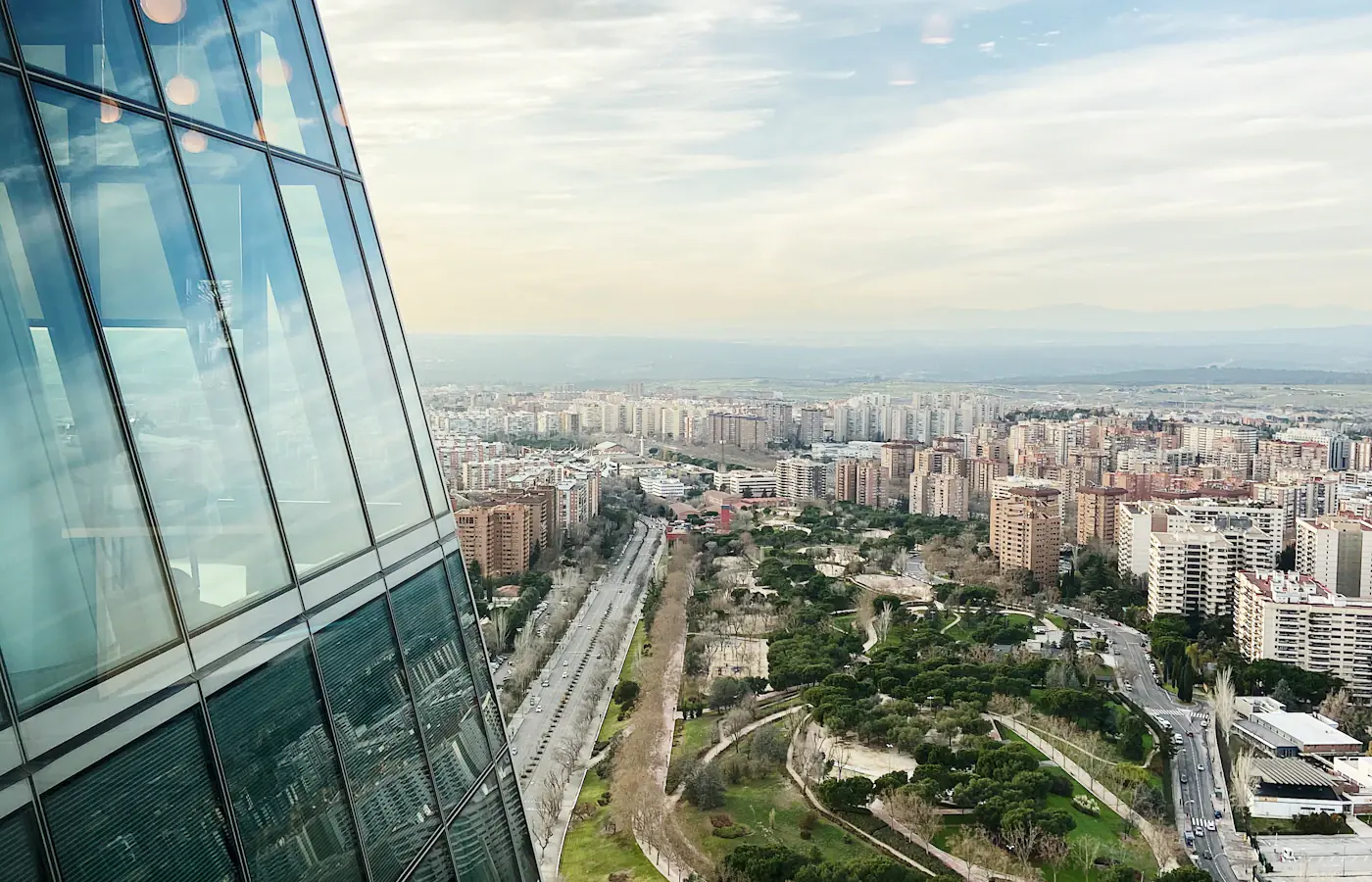 Streets and buildings in Madrid next to the glass facade of Torre Espacio