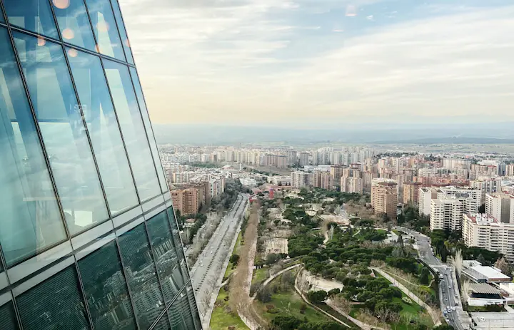 Streets and buildings in Madrid next to the glass facade of Torre Espacio