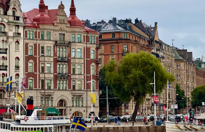 Stockholm waterfront with historic buildings and Swedish-flagged boats
