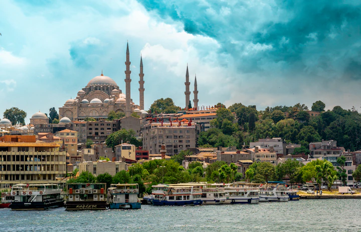 The Süleymaniye Mosque rising above waterfront buildings and boats in Istanbul, Turkey