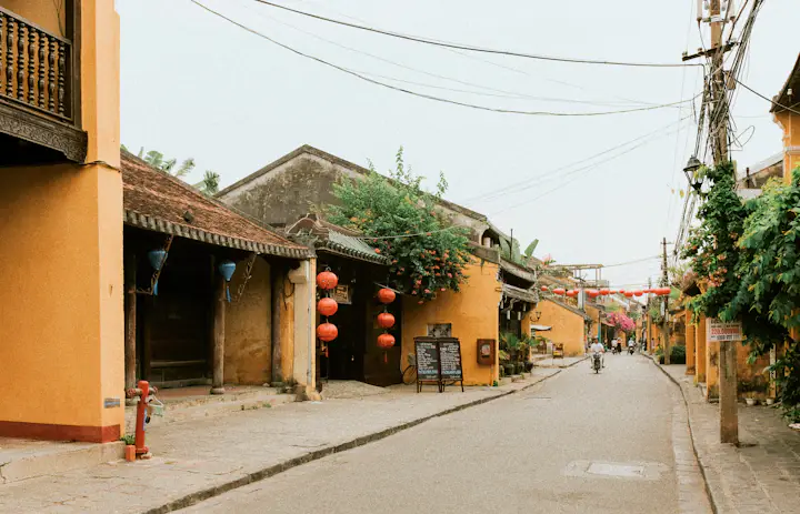 Leafy street and old-town buildings in Hoi An, Vietnam